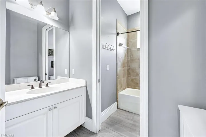 Bathroom featuring tile flooring, oversized vanity, and tiled shower / bath combo
