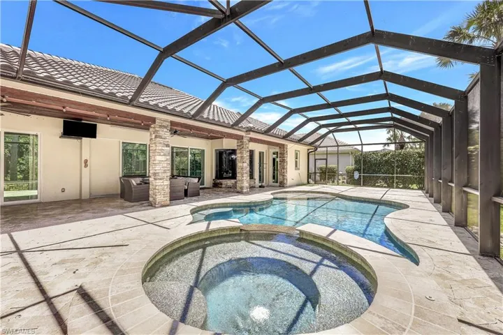 View of pool featuring a patio, screen enclosure, an in ground hot tub, and ceiling fan