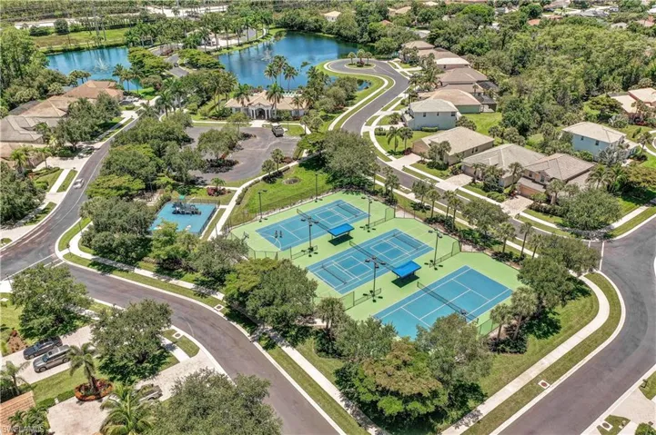 Community tennis and pickle ball courts. Drone / aerial view featuring a water view
