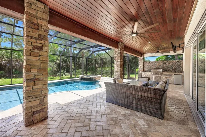 View of swimming pool with ceiling fan, area for grilling, an outdoor kitchen,  and patio area.
