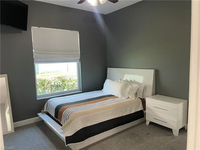 Bedroom featuring ceiling fan and dark colored carpet