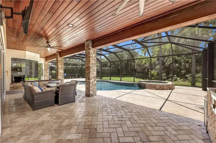 View of patio / terrace with outdoor lounge area, a lanai, ceiling fan, and a swimming pool with hot tub