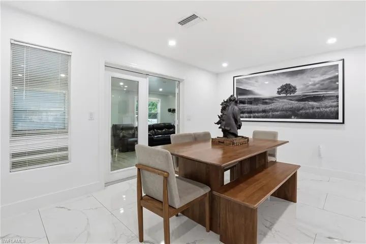 Dining room with recessed lighting and light marble finish floors