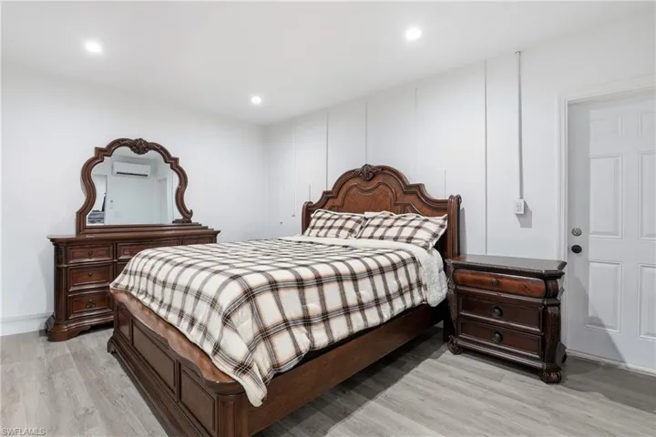 Bedroom with light wood-style floors, recessed lighting, and a mini split for heating / cooling