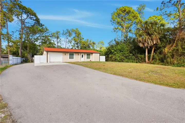 Single story home with driveway and a garage