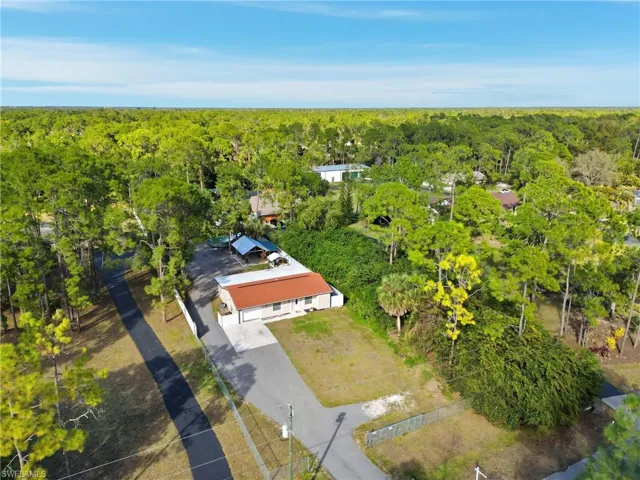Aerial view of property and surrounding area featuring a forest