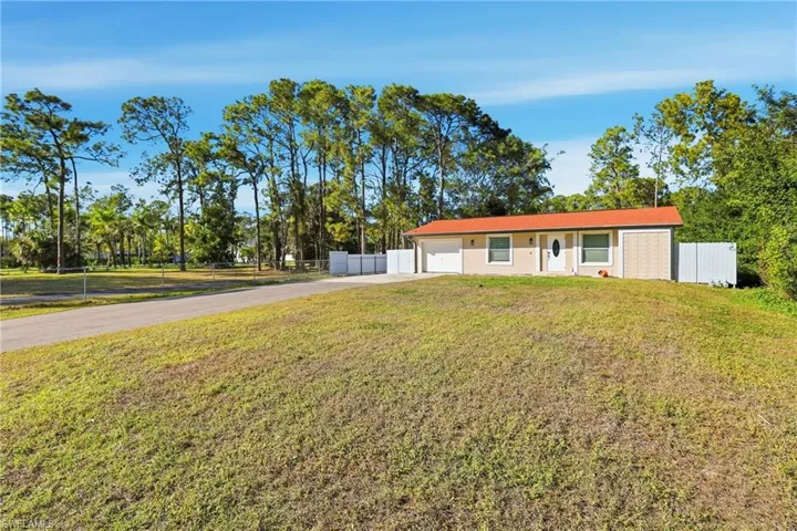 View of front of house with concrete driveway and an attached garage
