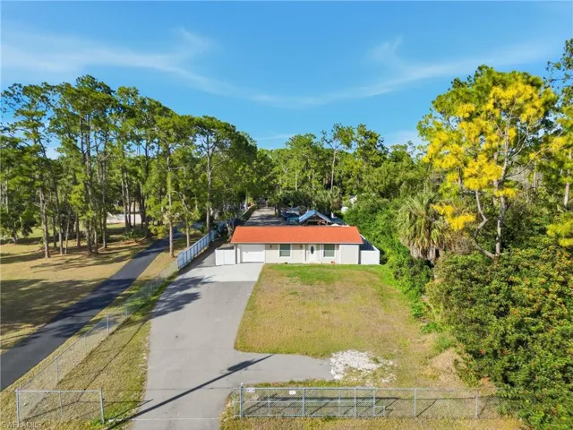 View of subject property with a tree filled landscape