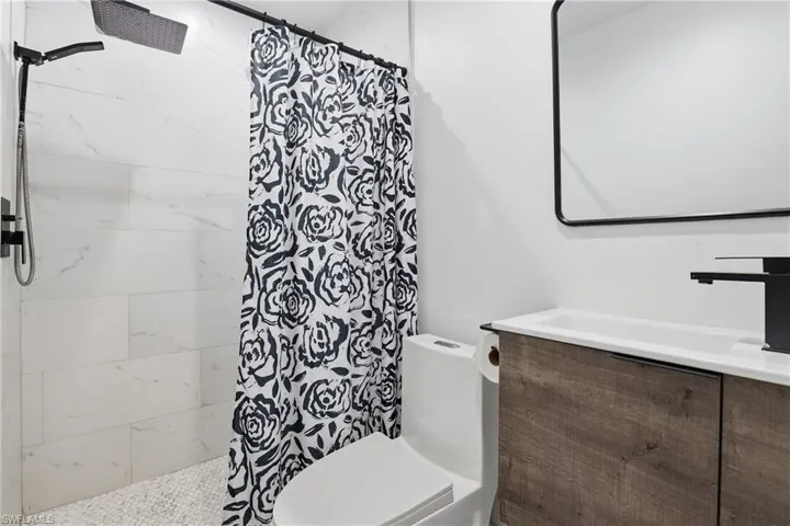 Bathroom featuring a tile shower and vanity