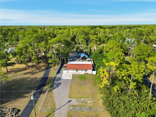 Aerial view of property and surrounding area featuring a heavily wooded area
