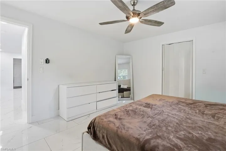 Bedroom featuring marble finish floors and a ceiling fan