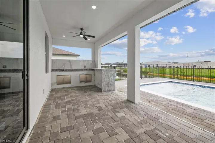 View of patio featuring ceiling fan and a fenced in pool
