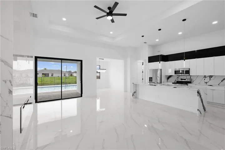 Kitchen with white cabinetry, a raised ceiling, appliances with stainless steel finishes, and light tile patterned flooring