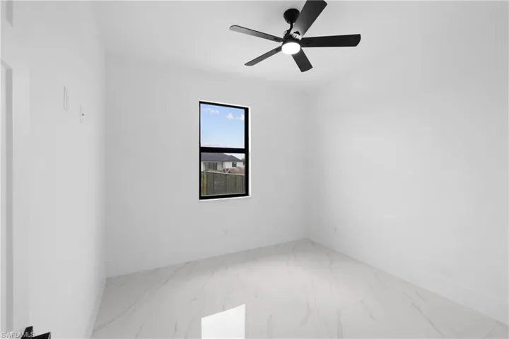 Spare room featuring ceiling fan and tile patterned flooring