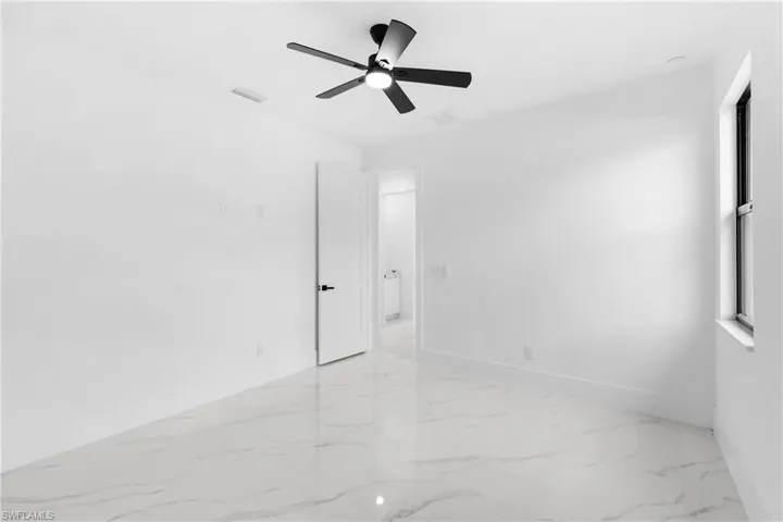 Spare room with ceiling fan and light tile patterned flooring
