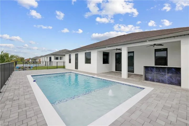 View of swimming pool with ceiling fan and a patio area