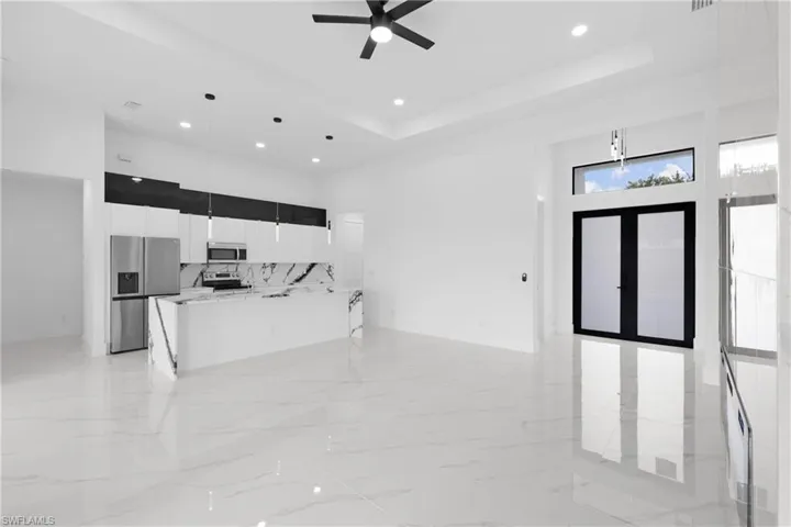 Kitchen featuring ceiling fan, a raised ceiling, appliances with stainless steel finishes, and light tile patterned floors