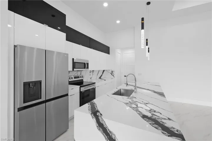 Kitchen with light tile patterned flooring, backsplash, sink, light stone countertops, and stainless steel appliances