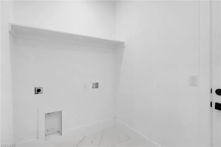 Washroom with hookup for an electric dryer, washer hookup, and tile patterned flooring