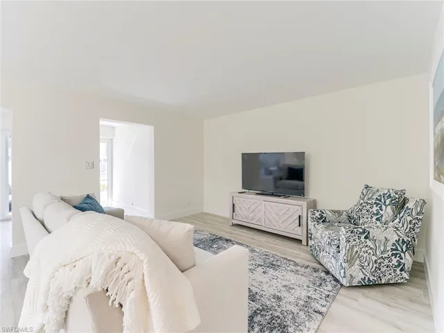 Living room with light wood-style flooring and baseboards