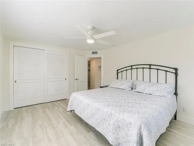 Bedroom featuring light wood-type flooring, a closet, and a ceiling fan