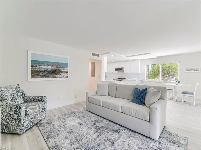Living area with light wood finished floors, recessed lighting, and electric panel