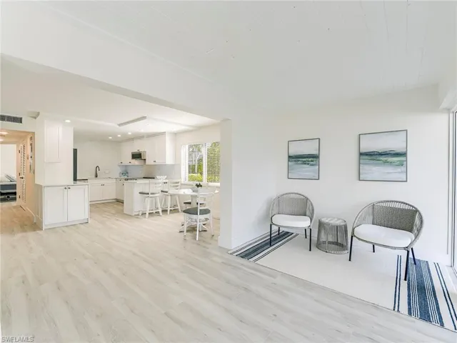 Sitting room with light wood finished floors and recessed lighting