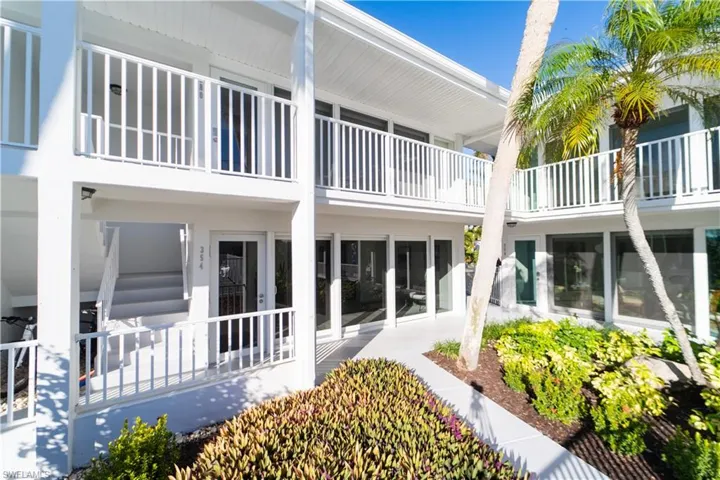 Back of property featuring a balcony and a patio area