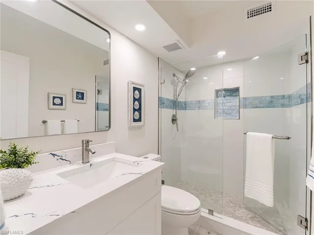 Full bath featuring vanity, a stall shower, and recessed lighting