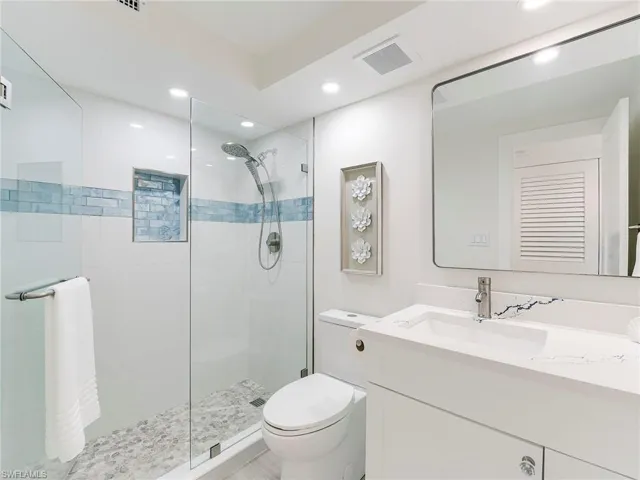 Bathroom with vanity, a stall shower, and recessed lighting
