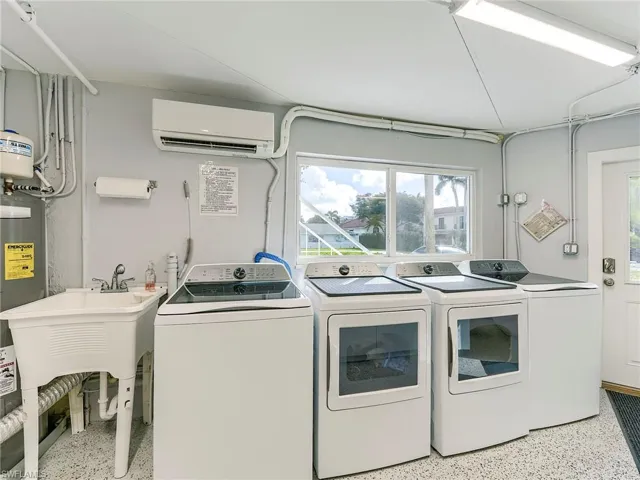 Laundry area featuring dark aggregate flooring, separate washer and dryer, and water heater