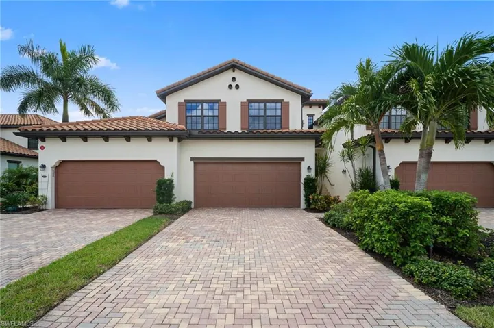 Mediterranean-style exterior featuring a tile roof, stucco finish, and decorative window shutters