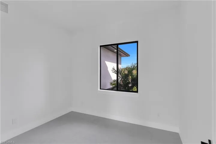 Unfurnished room with concrete flooring and baseboards