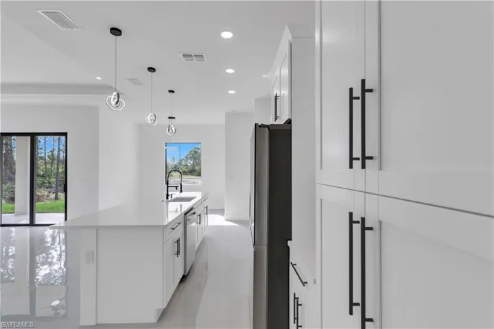 Kitchen with appliances with stainless steel finishes, recessed lighting, white cabinets, and visible vents