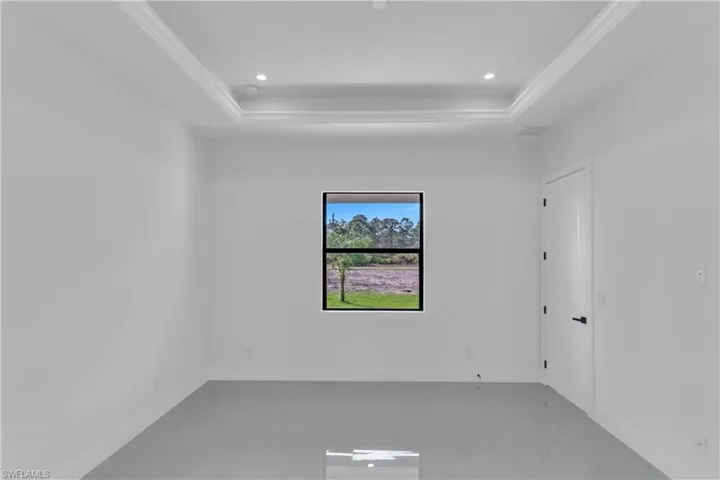 Empty room with visible vents, baseboards, a raised ceiling, and recessed lighting