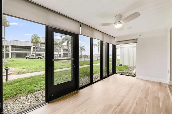 Unfurnished sunroom featuring plenty of natural light, ceiling fan, and wood finished floors
