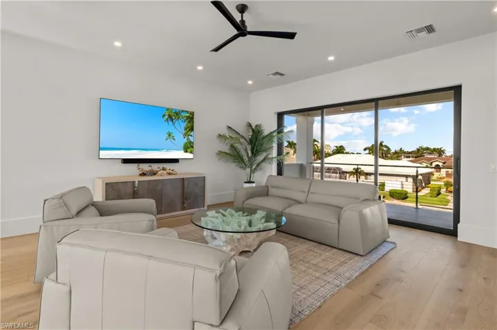 Living room with recessed lighting, light wood-style flooring, and a ceiling fan