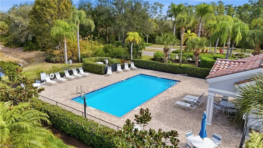 Community pool featuring a patio and view of scattered trees