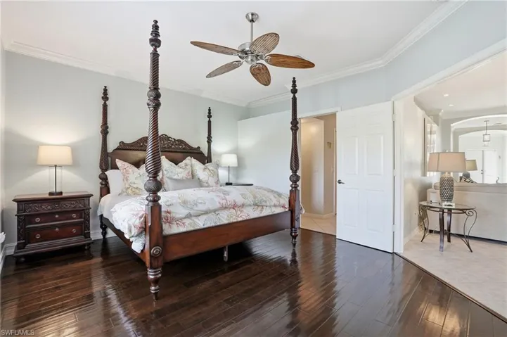 Bedroom with crown molding, hardwood / wood-style flooring, and a ceiling fan