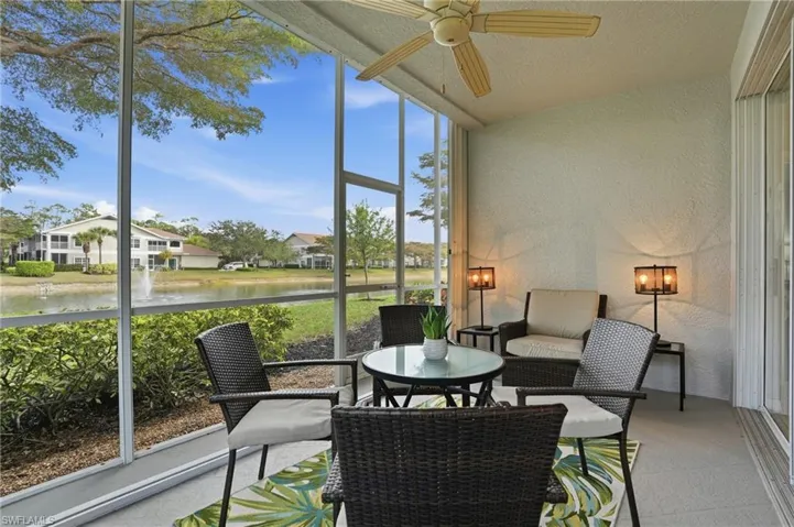 Sunroom / solarium with a ceiling fan, a water view, vaulted ceiling, and outdoor dining space
