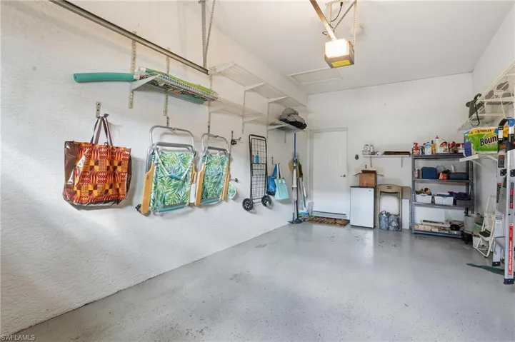Garage with freestanding refrigerator and a garage door opener