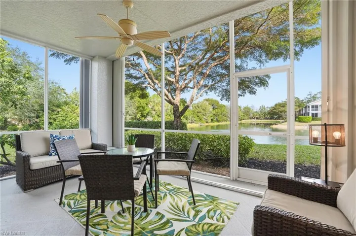 Sunroom with outdoor seating, a ceiling fan, and a water view