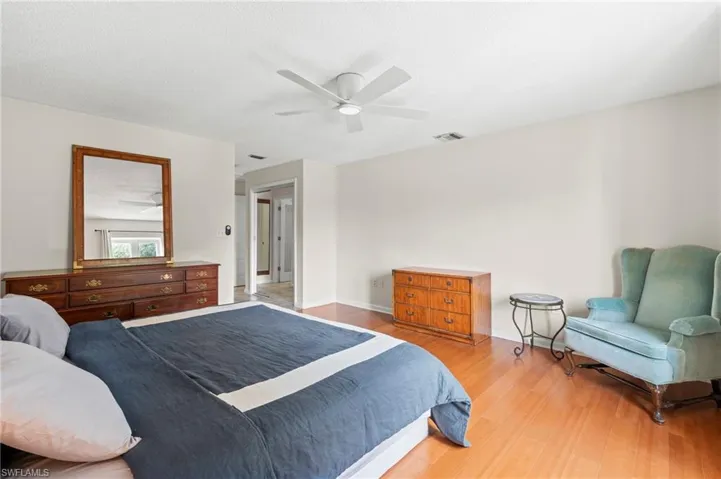 Bedroom with wood finished floors, a ceiling fan, and baseboards