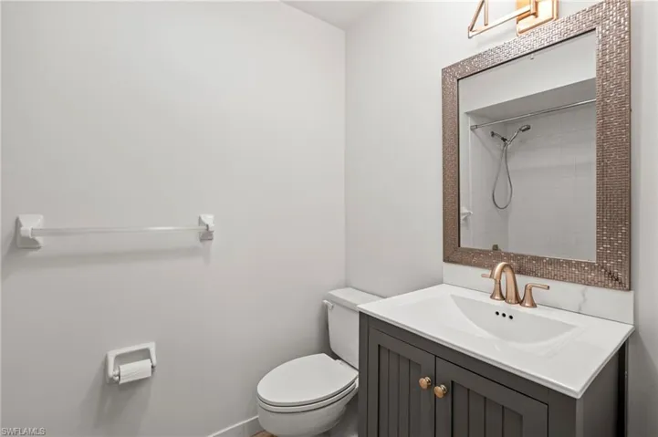 Bathroom with toilet, vanity, and a shower