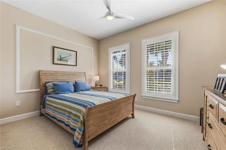 Bedroom featuring light colored carpet and ceiling fan