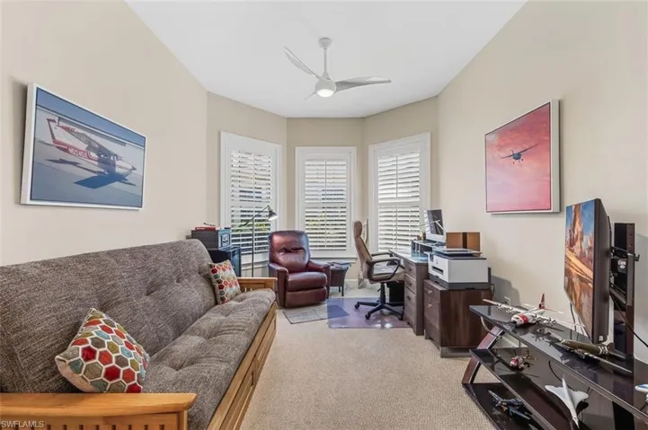 Office with ceiling fan and light colored carpet