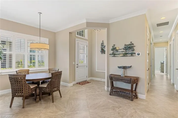 Dining space with ornamental molding and recessed lighting