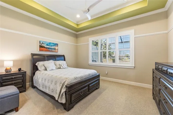Bedroom with light colored carpet and ornamental molding