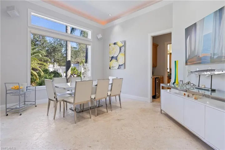 Dining area featuring ornamental molding and light floors