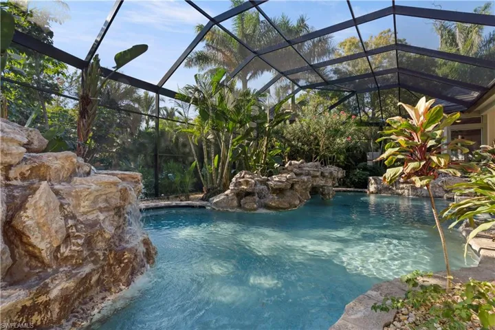 Swimming pool featuring glass enclosure and a sunroom